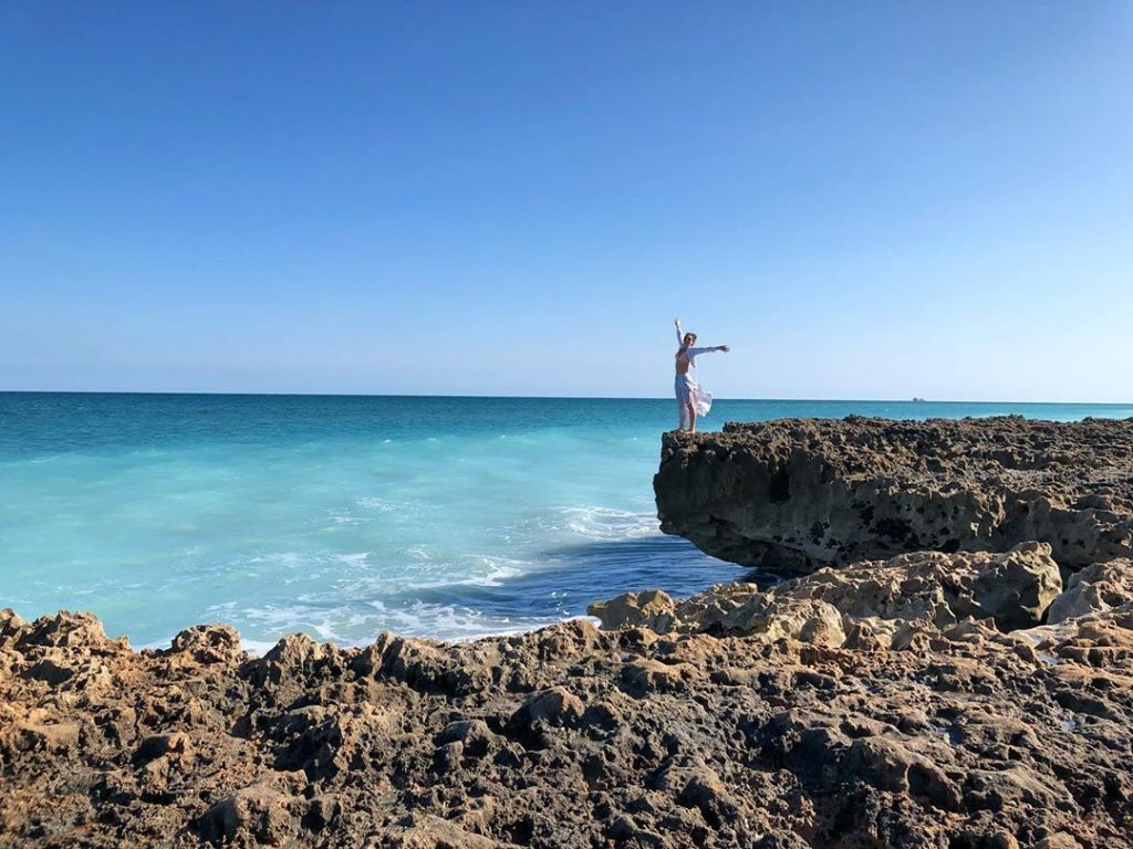 Woman Standing at the ocean edge enjoying the sun